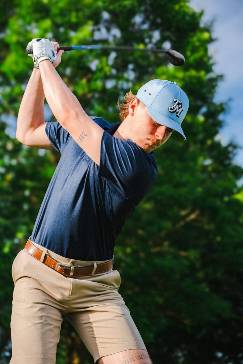 Golfer mid-swing in a light blue cap, photographed by Jubilee