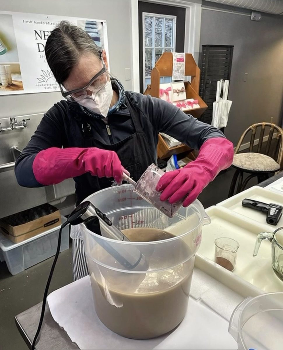 New Day Organics team member making skincare product by hand