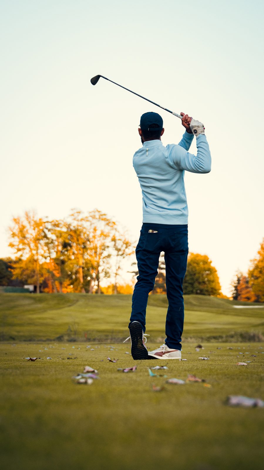 A golfer swinging on an autumn fairway at Lake Forest Country Club